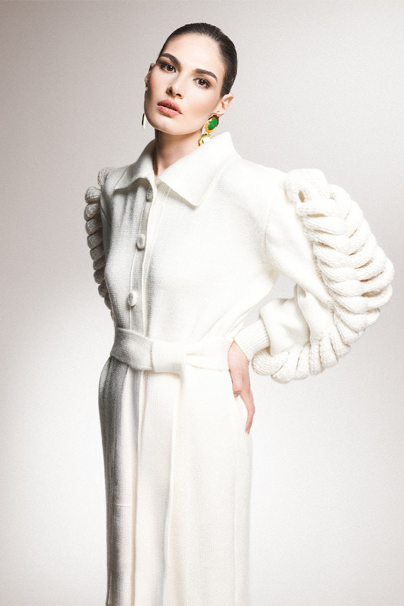 Liya dramatic knit belted white coat displayed on a hanger, showing its stylish design and cozy fabric for fall and winter wear.