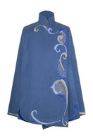 Nadya Shah Olympia denim cape jacket displayed on a mannequin, showcasing its stylish design and denim fabric.