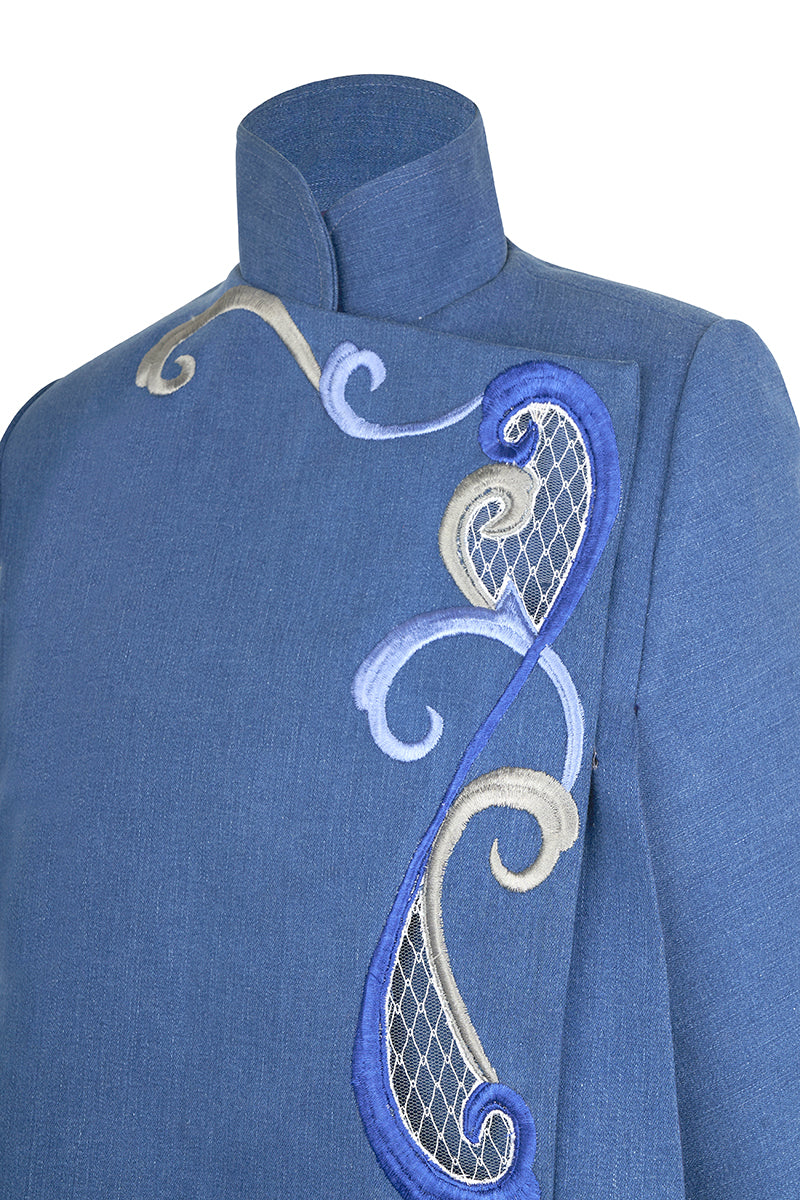 Nadya Shah Olympia denim cape jacket displayed on a mannequin, with detailed stitching and classic denim look.