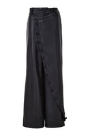 Black crossed leather pants by MAZ Manuela Álvarez, showcasing a stylish design with crossed leather panels and a sleek fit.