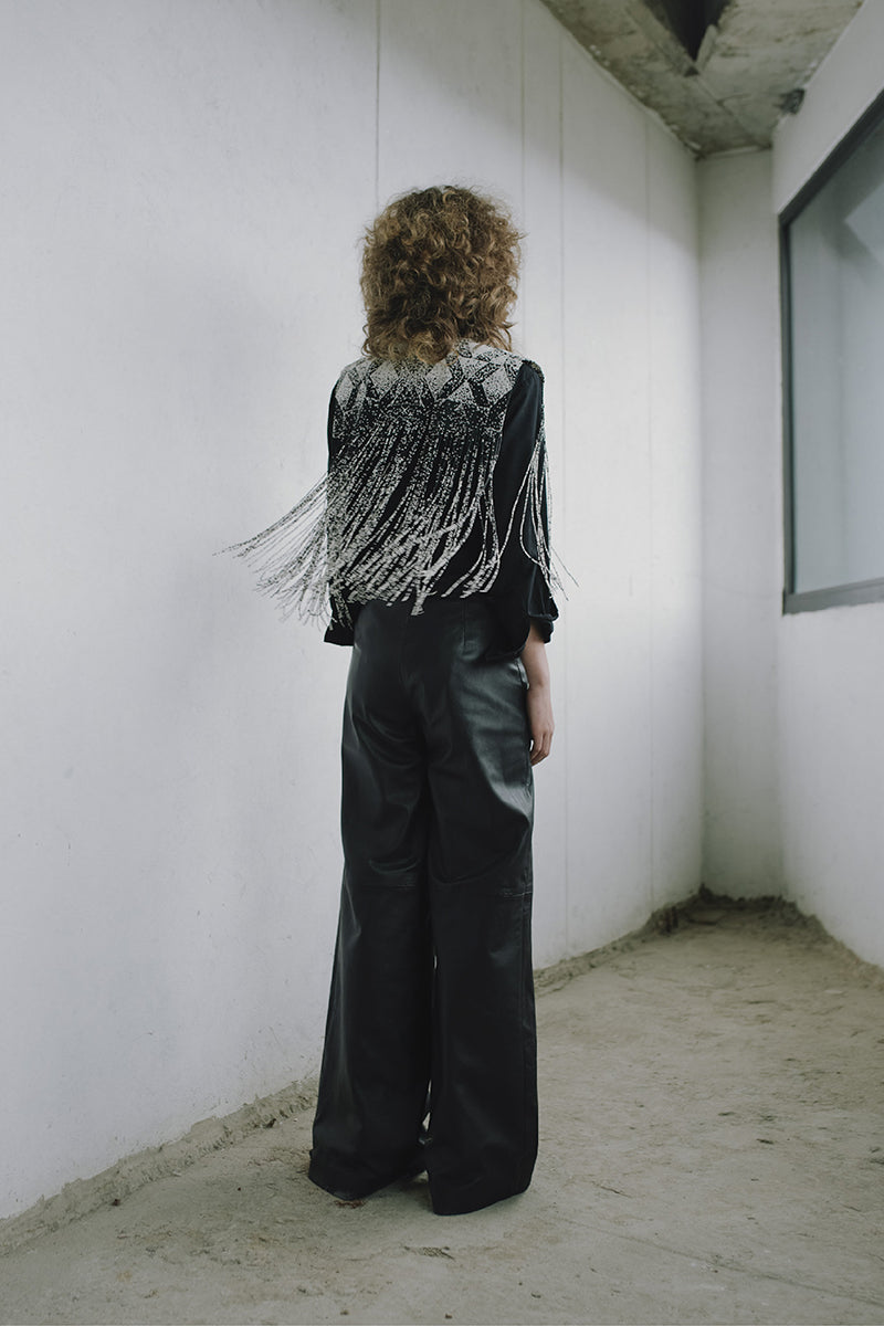 Black crossed leather pants by MAZ Manuela Álvarez featuring a stylish, fitted design with crossed details on the front.