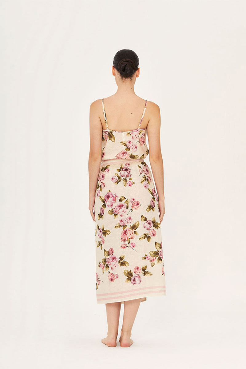 Aaguaclara rose wrap midi skirt in soft pink fabric, styled with a flattering waist tie and flowing hem, perfect for casual or dressy wear.