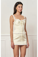 Light yellow cake bustier top by Stolen Stores, featuring a fitted design with decorative details, perfect for stylish outfits.