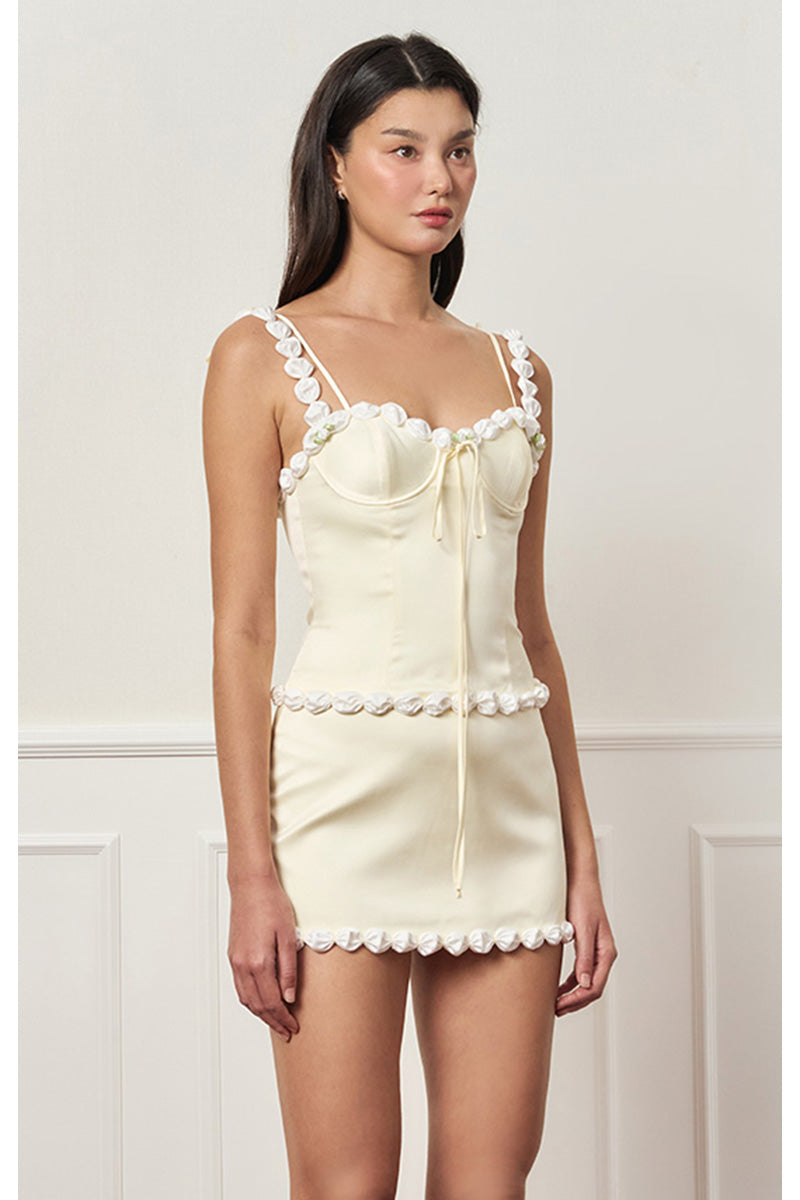 Light yellow cake bustier top by Stolen Stores, featuring a fitted design with decorative details, perfect for stylish outfits.