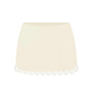 Light yellow Cake mini skirt by Stolen Stores shown on a model, highlighting its fitted waistband and stylish mini length.