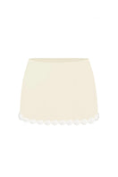 Light yellow Cake mini skirt by Stolen Stores shown on a model, highlighting its fitted waistband and stylish mini length.