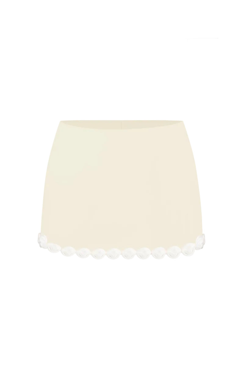 Light yellow Cake mini skirt by Stolen Stores shown on a model, highlighting its fitted waistband and stylish mini length.