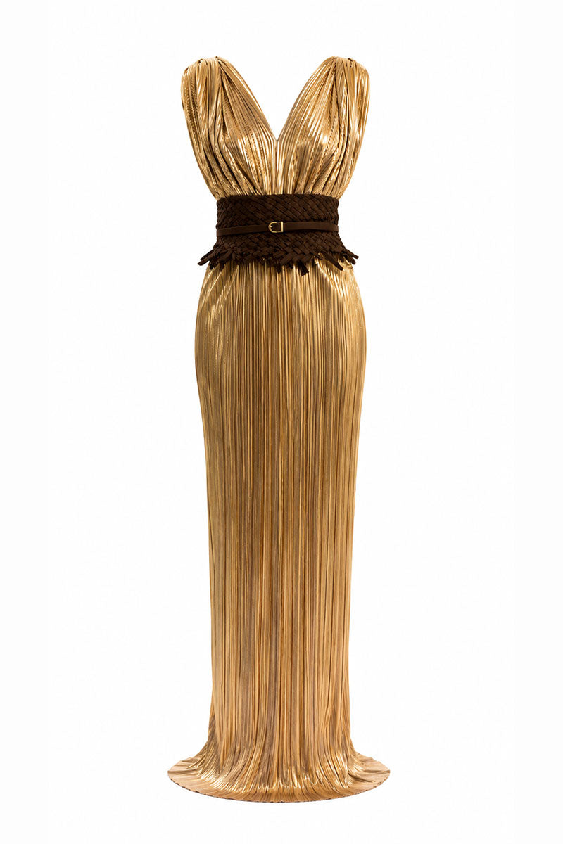 Elegant gold Candela dress gown by Maylé Vásquez, featuring flowing fabric and intricate detailing, perfect for formal occasions.