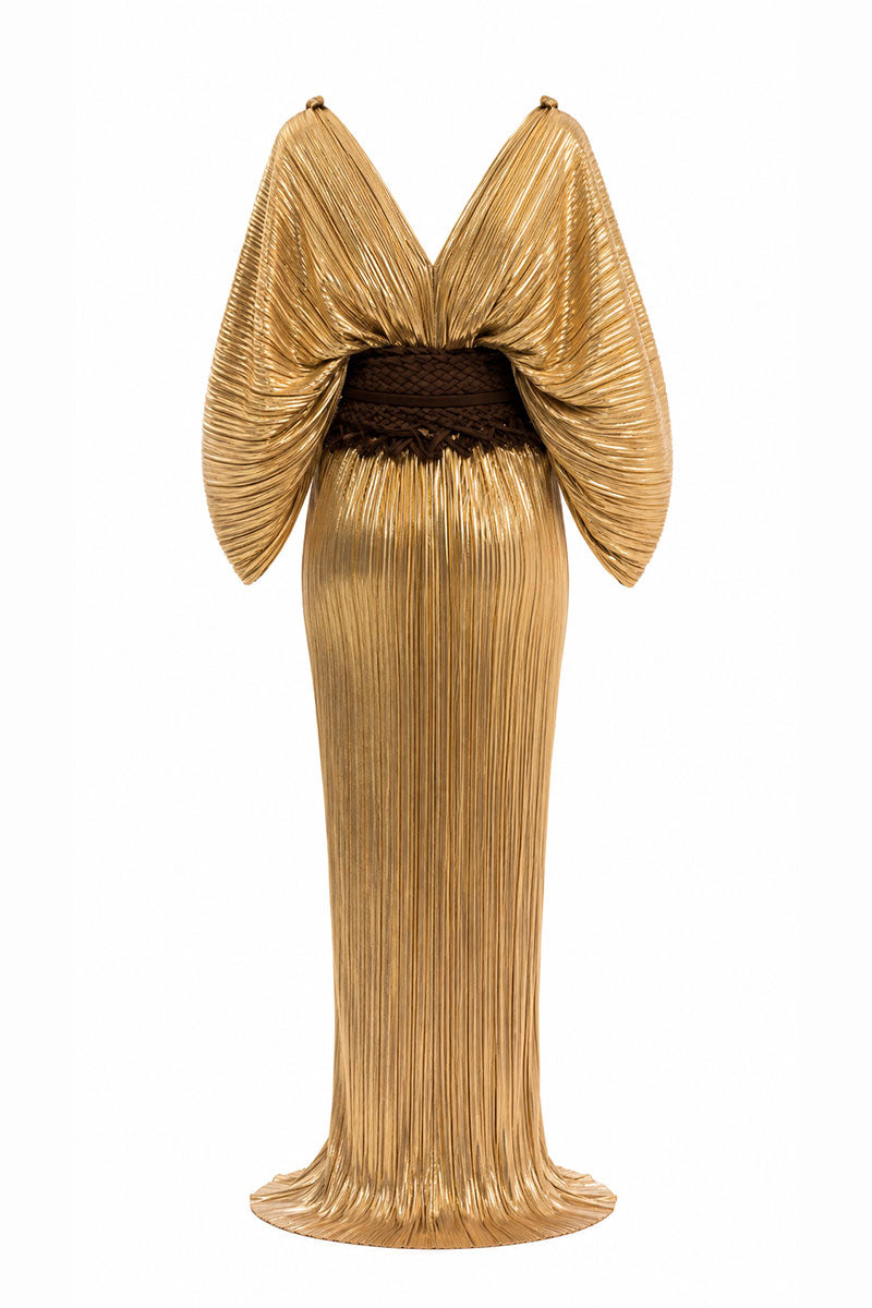 Gold Candela dress by Maylé Vásquez, elegant gown with intricate details and flowing fabric, perfect for formal occasions.