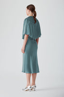Elegant MASTANI Saxon slip dress in midi length with a cape design, displayed on a model with flowing fabric.