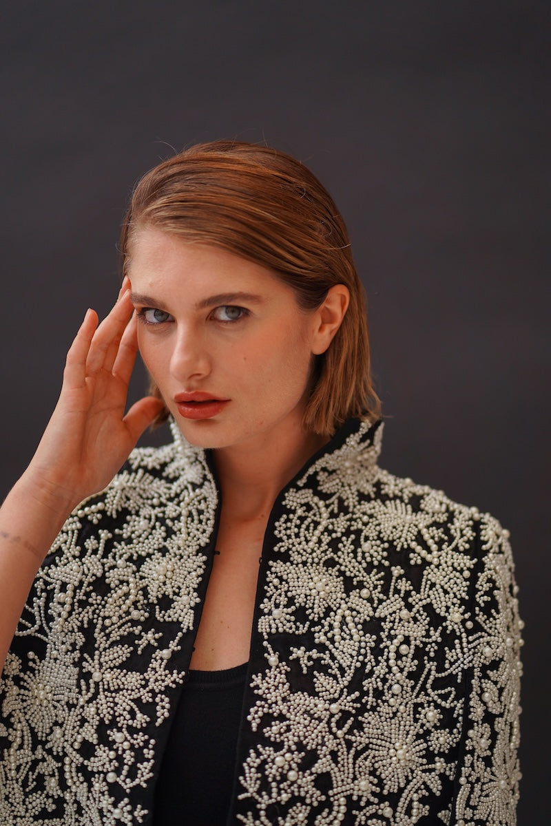 Nadya Shah Cape Anais jacket displayed on a model, featuring a stylish design with flowing fabric and elegant detailing.