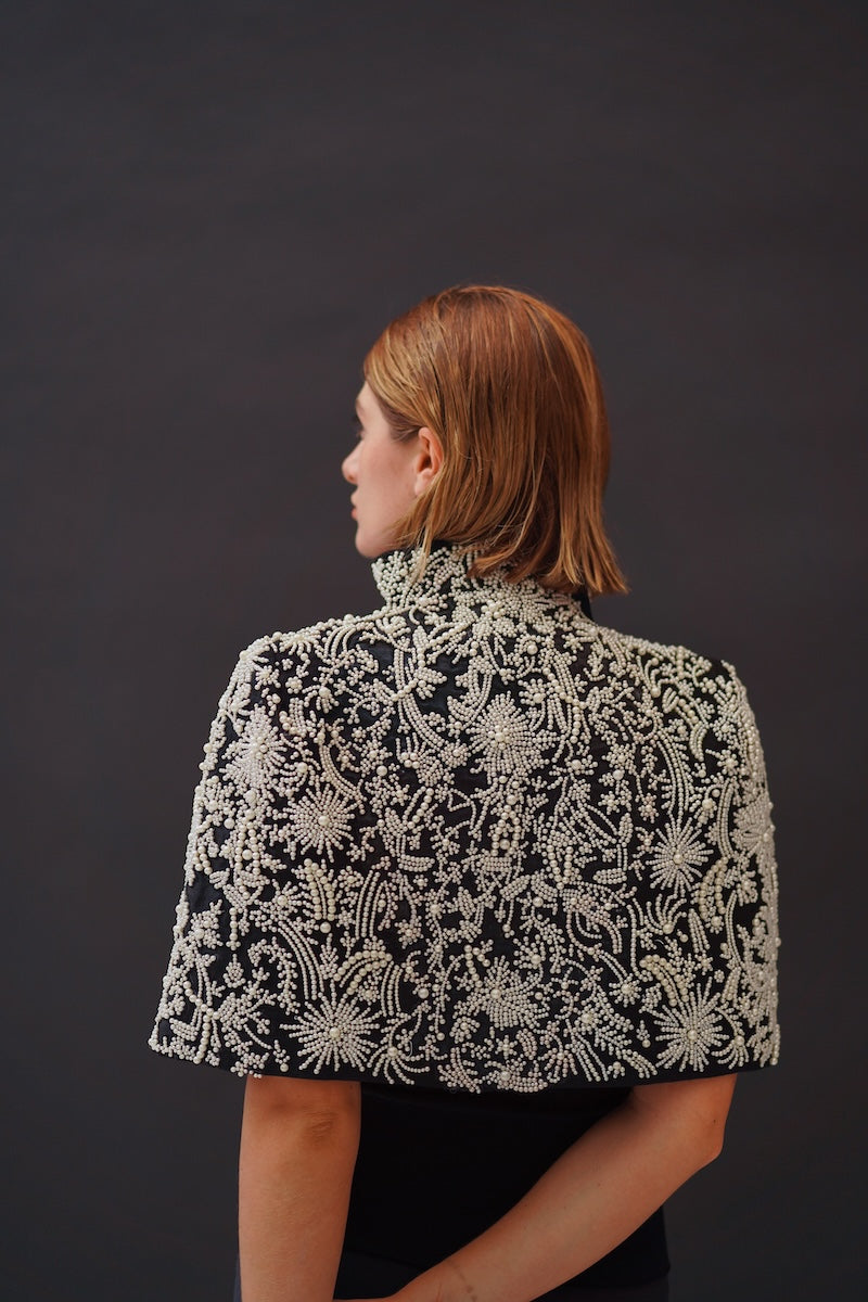 Nadya Shah Cape Anais jacket featuring elegant fabric and stylish design, displayed on a hanger.