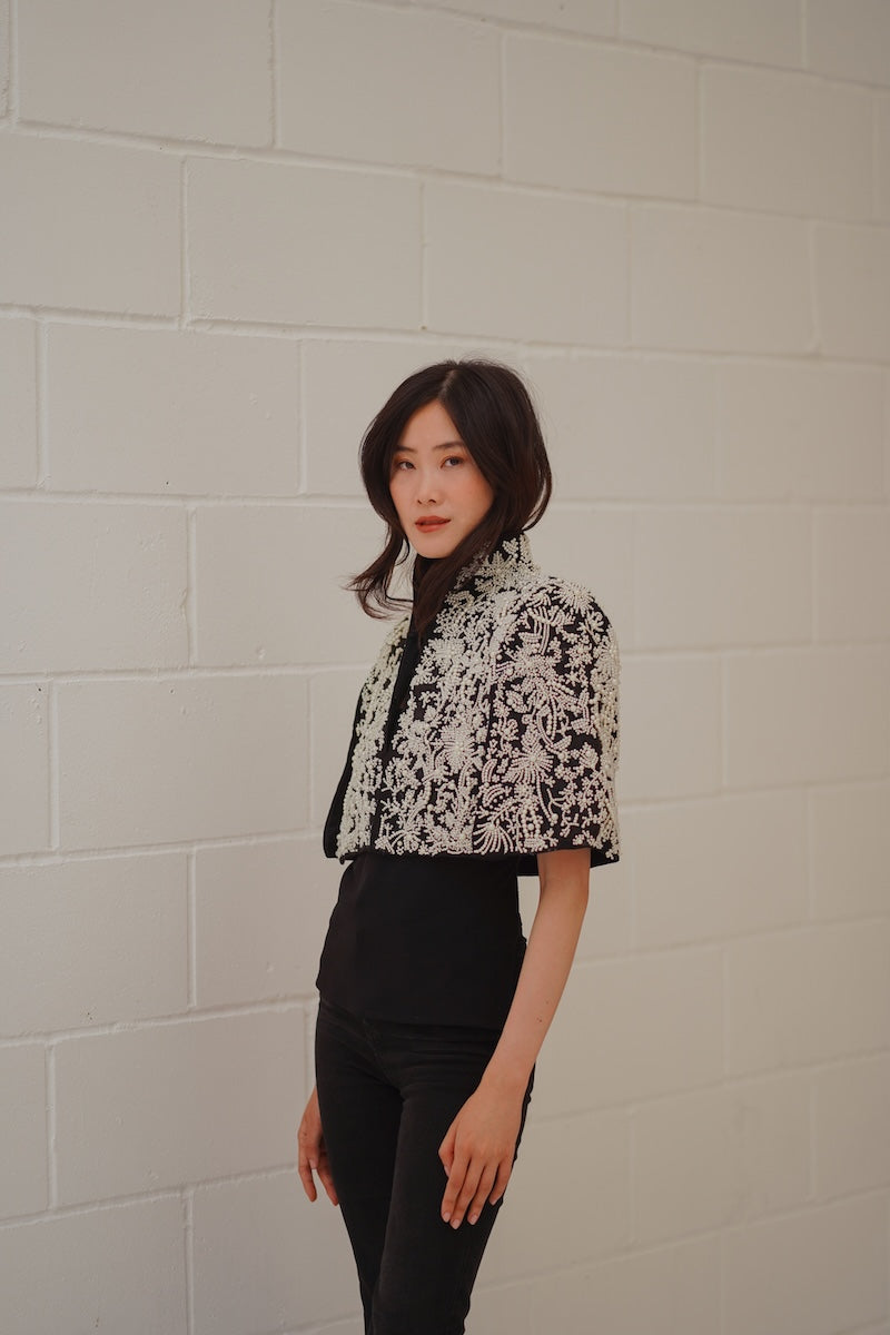 Nadya Shah Cape Anais jacket in soft fabric, featuring a stylish cape design with elegant detailing and a modern silhouette.