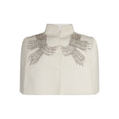 Nadya Shah Cape Eclat Ivory jacket displayed on a hanger, showcasing its elegant ivory fabric and stylish design.