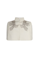 Nadya Shah Cape Eclat Ivory jacket displayed on a hanger, showcasing its elegant ivory fabric and stylish design.
