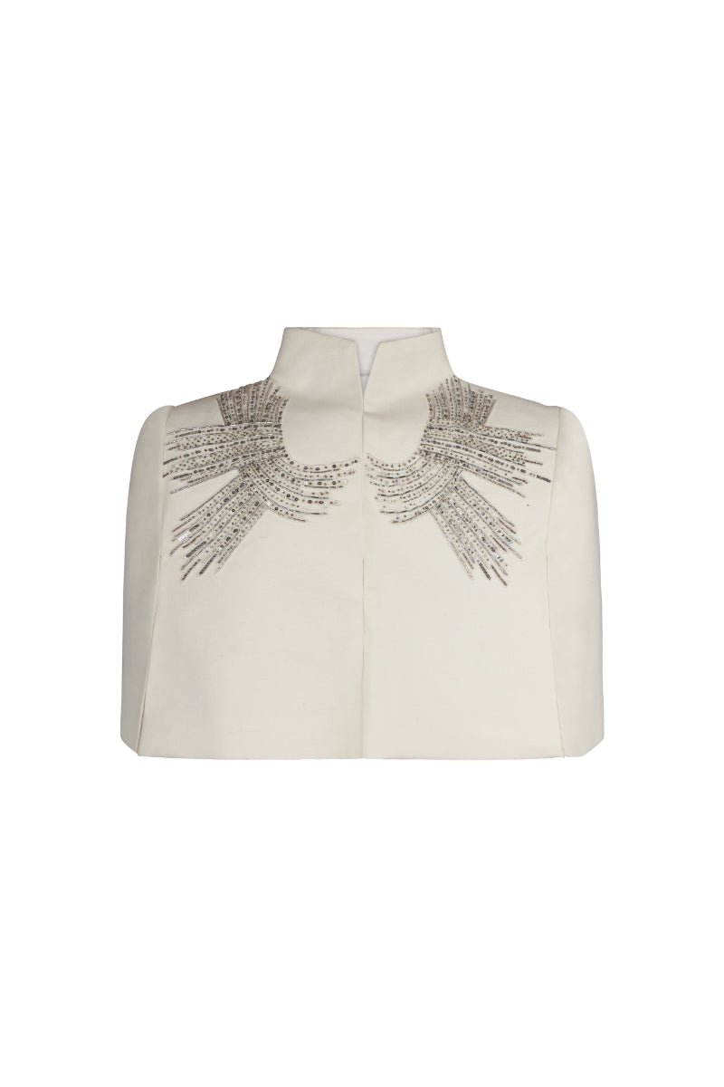 Nadya Shah Cape Eclat Ivory jacket displayed on a hanger, showcasing its elegant ivory fabric and stylish design.
