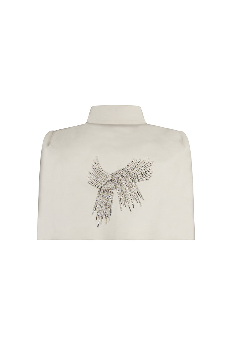Ivory cape jacket by Nadya Shah, styled with elegant draping and a soft fabric texture, perfect for sophisticated winter looks.