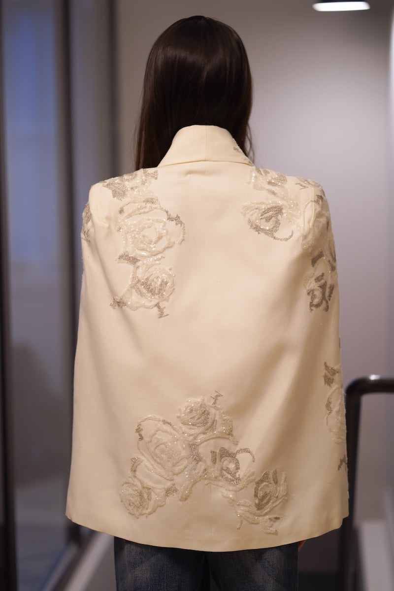 Nadya Shah LUMIERE cape jacket draped over a mannequin, showcasing its elegant design and flowing fabric.