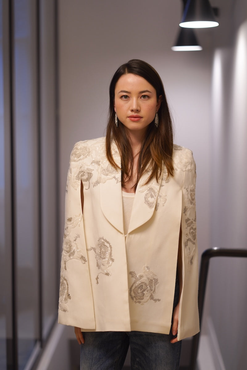 Nadya Shah Lumiere Cape jacket shown from the front, featuring a flowing, elegant design in soft fabric.