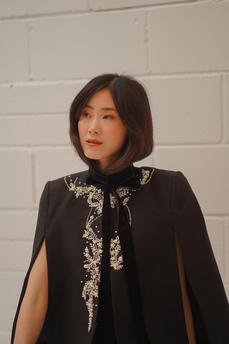 Nadya Shah Cape Nocturne jacket featuring a flowing, elegant design with dark, luxurious fabric and intricate detailing.