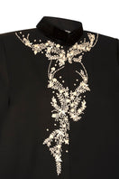 Nadya Shah Cape Nocturne jacket with detailed fabric and elegant design, showcased on a model in a stylish outdoor setting.