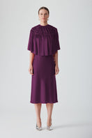 Aubergine MASTANI slip dress in midi length with a flowing cape detail, styled on a model for elegant evening wear.