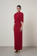 Red MOAZ maxi dress by HACCHIC COUTURE displayed on a model, showcasing its elegant flowing fabric and stylish design.