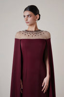 Long burgundy gown by HACCHIC COUTURE featuring long sleeves and elegant design, shown on a model.