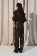 Green leather cargo pants with soldier-style pockets by Kris Marán, featuring a rugged, stylish design and functional utility details.