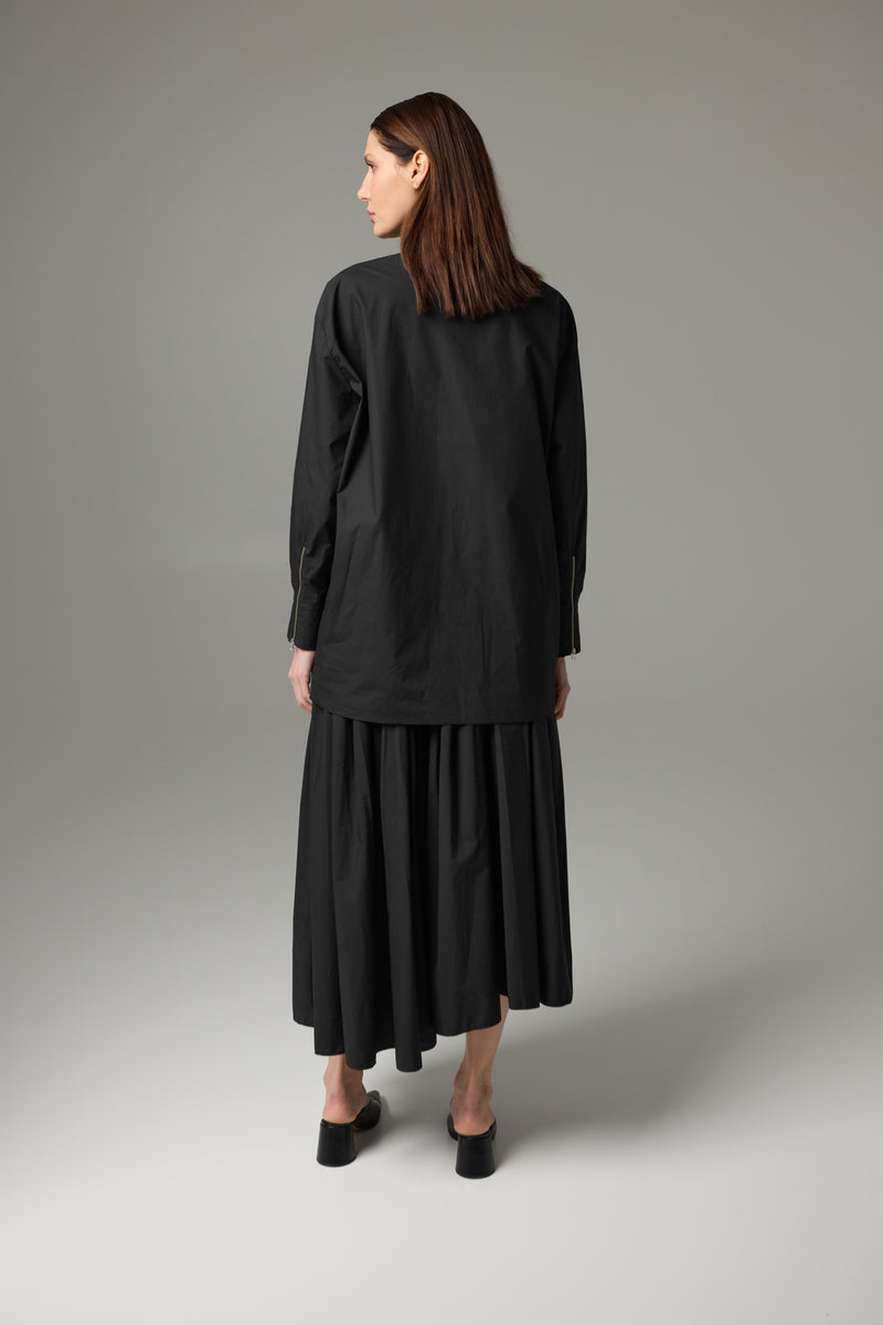 Black Carmen midi skirt by Tamar Keburia, featuring a sleek, fitted design and smooth fabric, shown on a model.