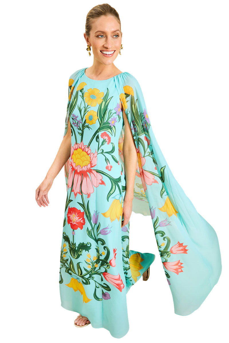 Mestiza New York Cartagena convertible cape gown in San Juan Garden, flowing maxi dress with cape detail, worn while walking outdoors.