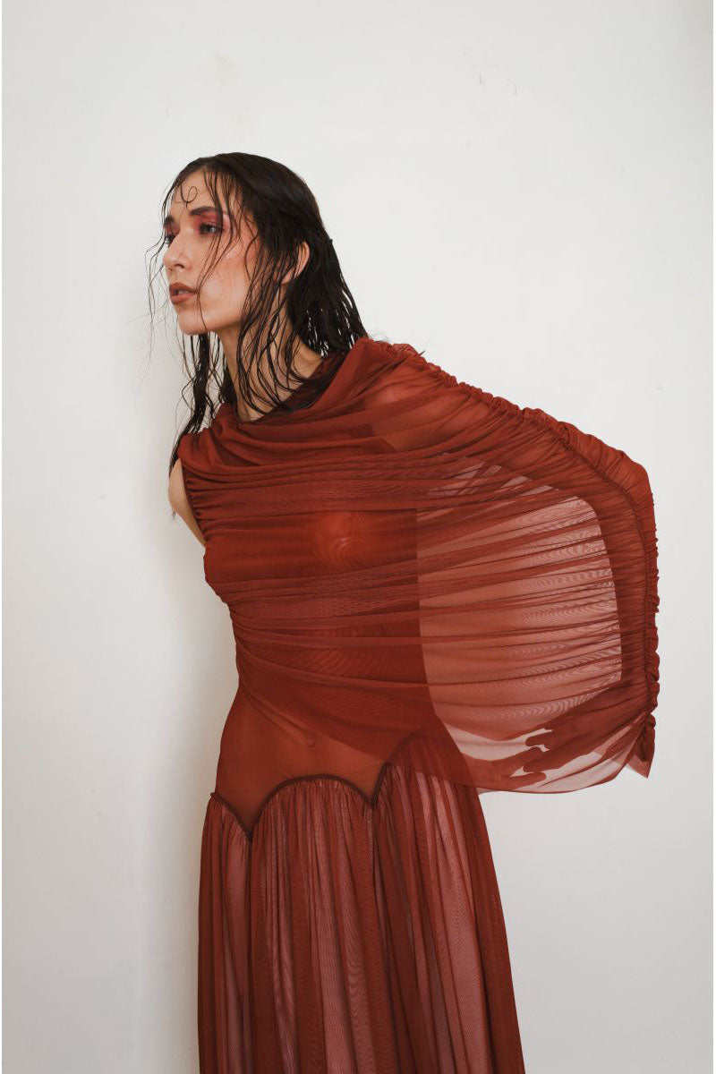Close-up of YASSMIN SALEH Cascade Rust Maxi Dress showing flowing fabric and elegant design details.
