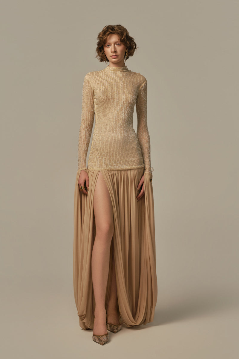 Poem Cascade gown in warm sand color, flowing fabric with elegant drape, worn by model showcasing its sophisticated style.