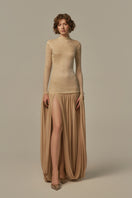 Poem Cascade Gown in Warm Sand color, elegant long dress with flowing fabric and subtle detailing modeled on a person.