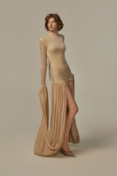 Poem Cascade gown in warm sand color, flowing evening dress with elegant drape and soft fabric, worn by model.