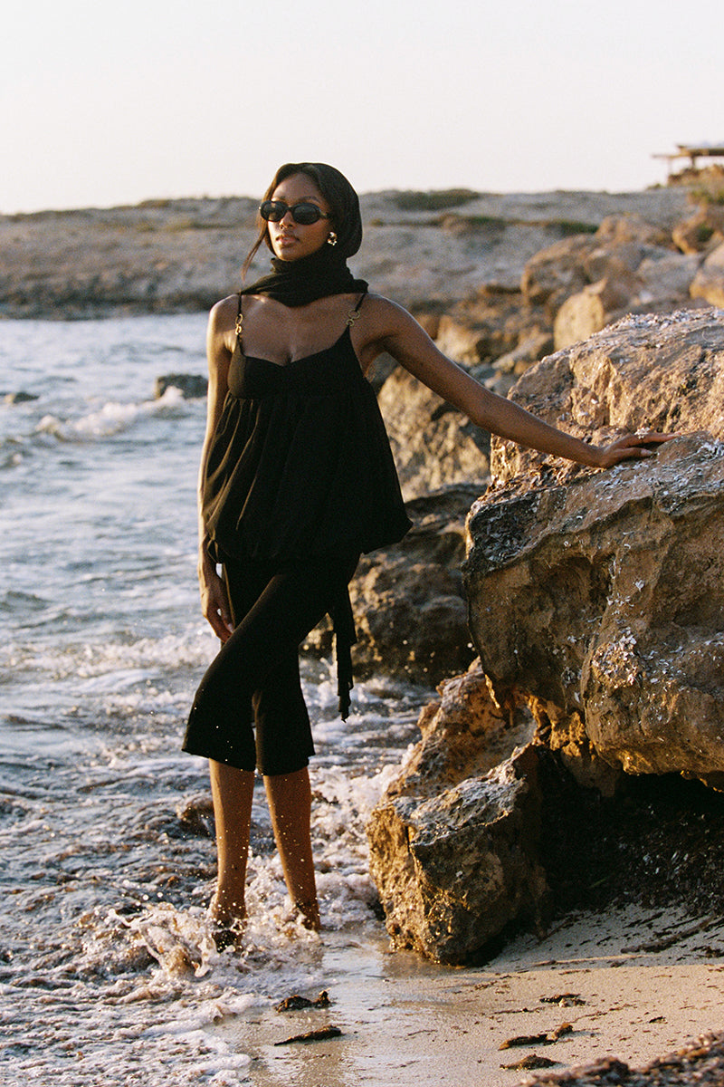 Black Cassia Capri flared pants by Nana Jacqueline, shown on a model in a stylish fashion shoot.