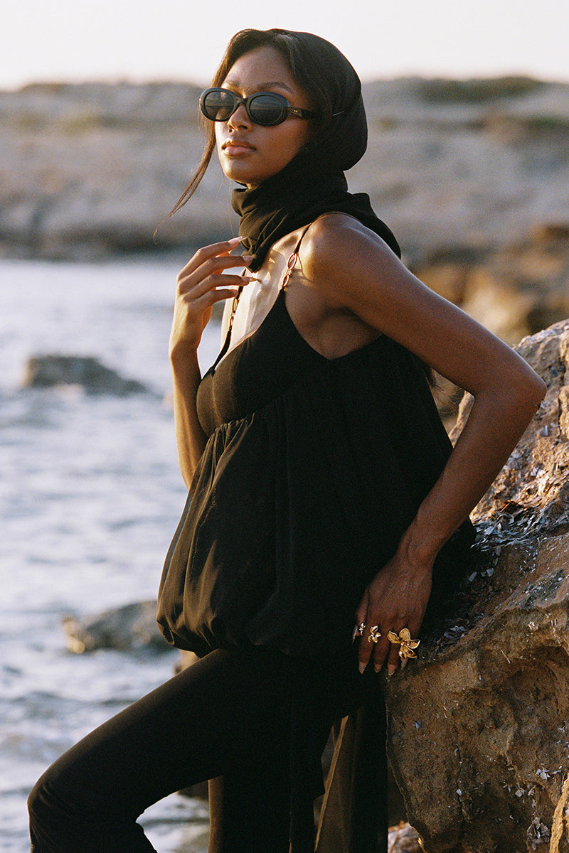 Black Cassia Capri flared pants by Nana Jacqueline, showing a stylish fit and smooth fabric in a fashion campaign setting.
