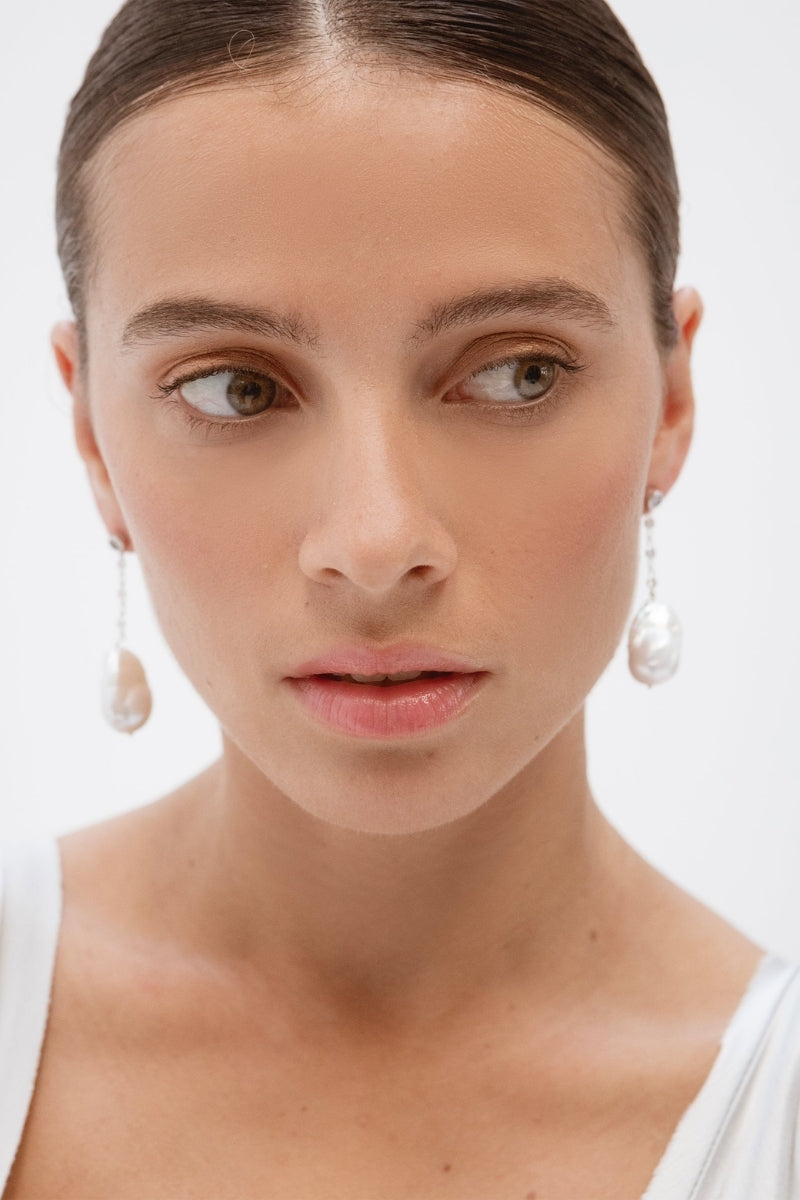 Silver Baroque Pearl Earrings by Celine, displayed on a neutral background, showcasing their elegant, irregular pearl design.