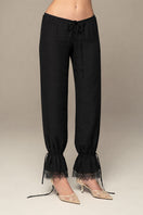 Black Scylla pants by IKINITA featuring a tailored fit and stylish design, displayed on a model against a neutral background.
