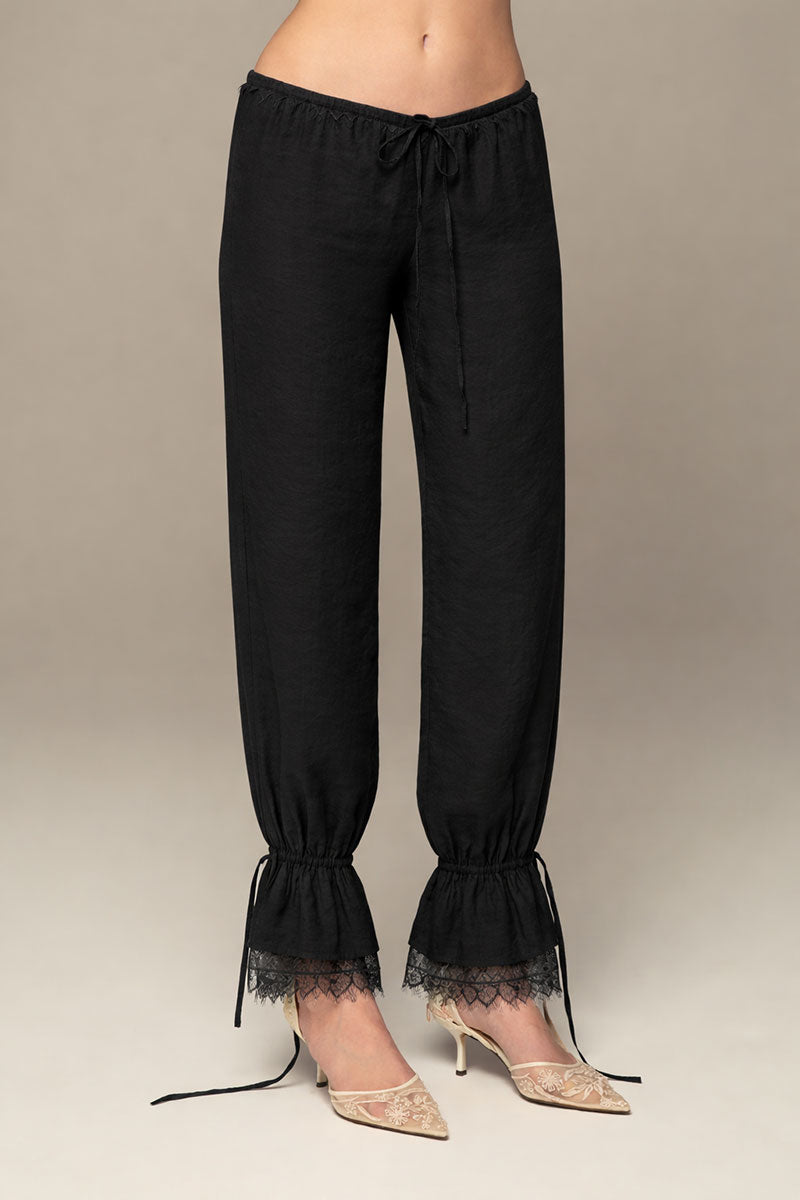 Black Scylla pants by IKINITA featuring a tailored fit and stylish design, displayed on a model against a neutral background.