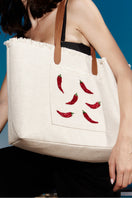 Sarah's Bag chilli-themed white travel shoulder bag with top handles and zipper closure, styled for travel or casual outings.