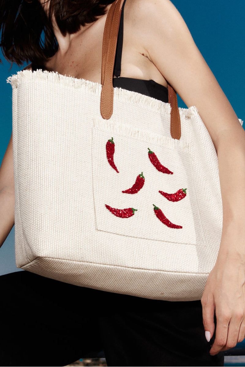 Sarah's Bag chilli-themed white travel shoulder bag with top handles and zipper closure, styled for travel or casual outings.