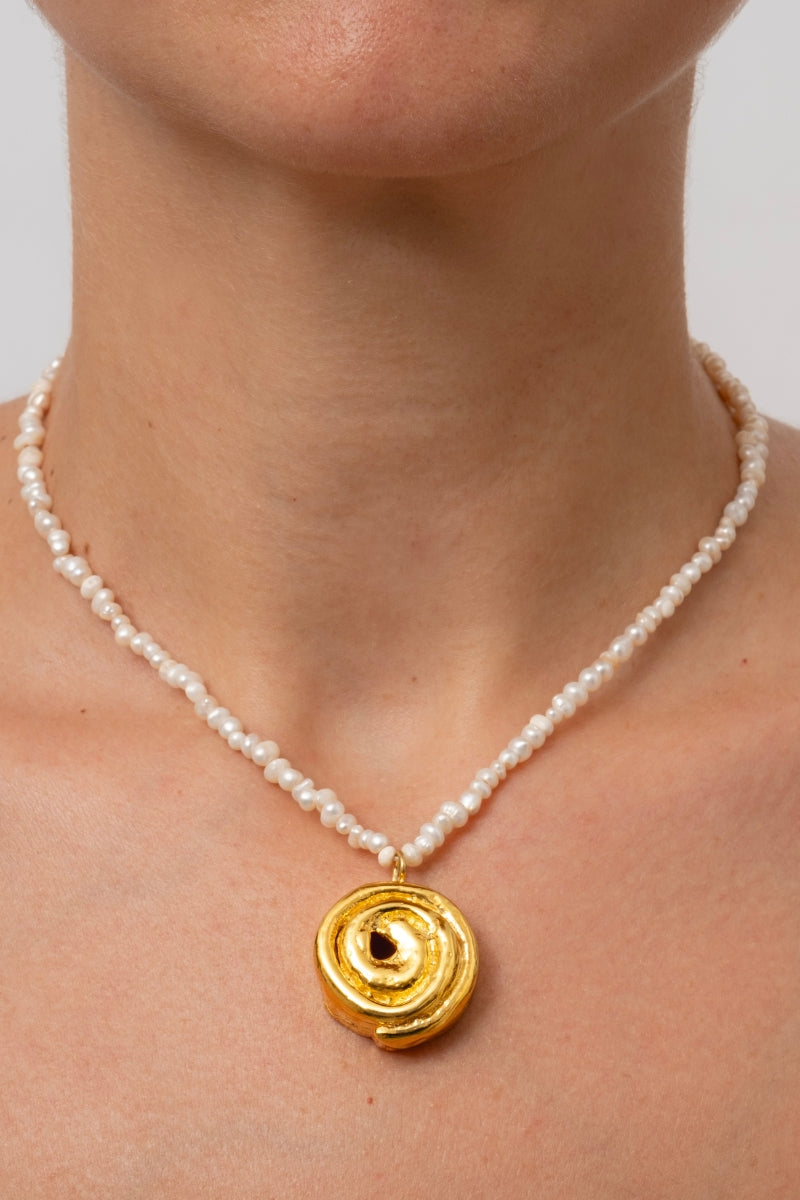 Gold cinnamon roll pendant necklace by Oz Objects featuring a detailed, sweet-inspired design.