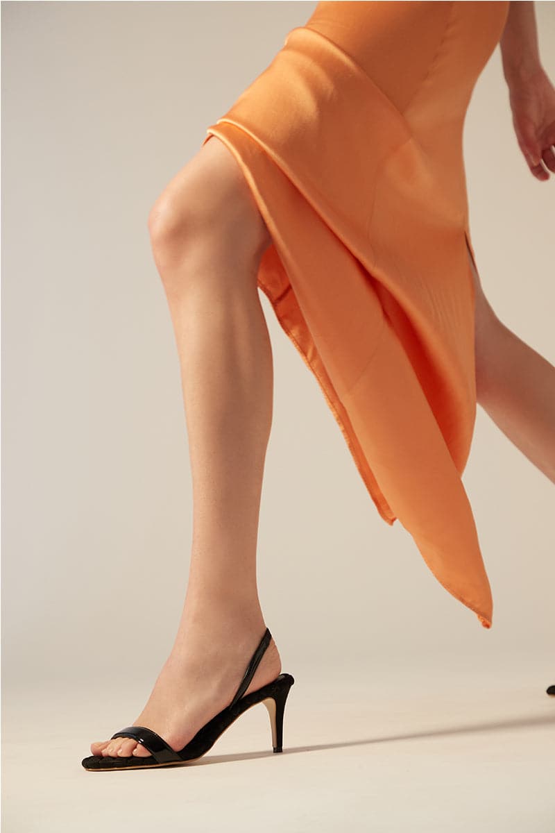 Black patent-effect slingback sandals by AERA featuring sleek straps and a stylish open heel design.
