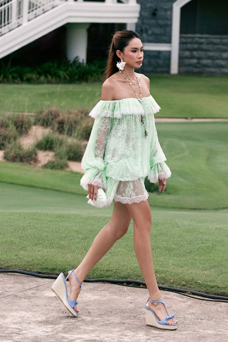 Valenciani off-shoulder lace mini dress with long sleeves, fitted silhouette, and intricate lace detailing.