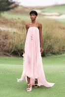 Valenciani strapless pleated pastel pink maxi dress displayed on a model, showcasing elegant flowing fabric and feminine style.