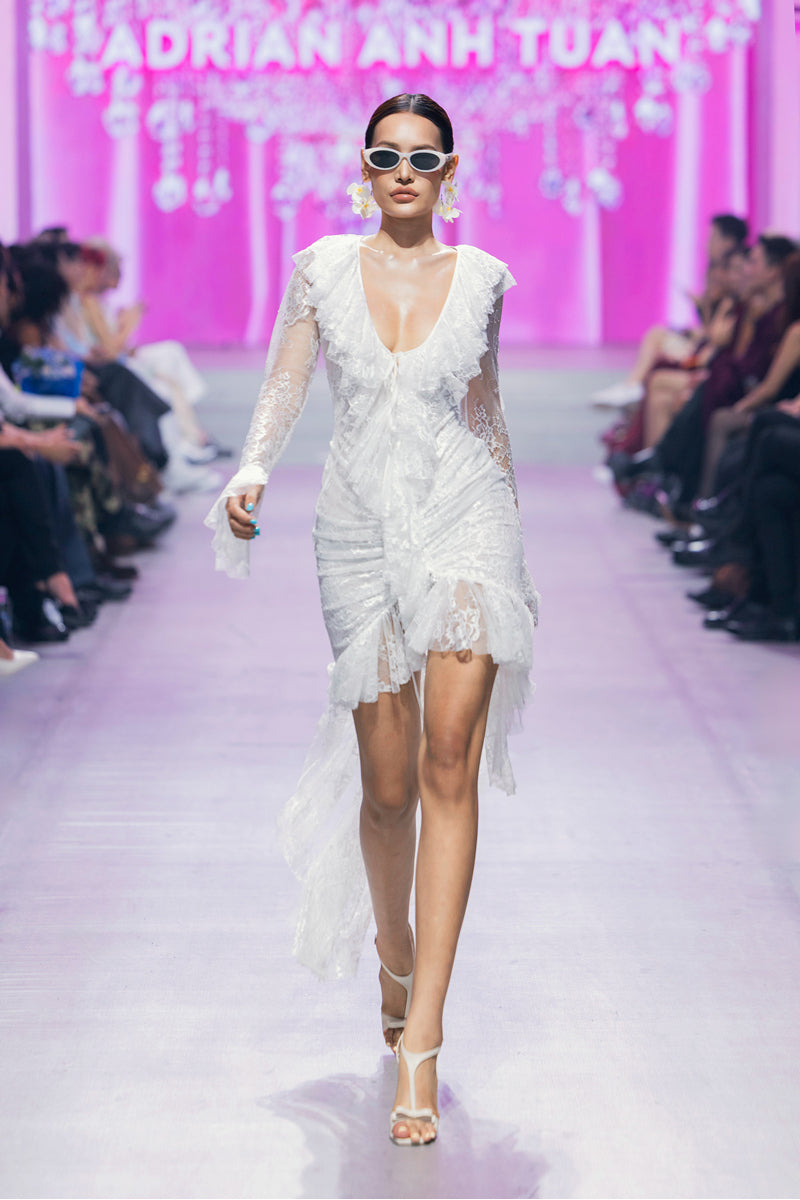 White Seraphina ruffle high-low midi dress by Valenciani, featuring flowing fabric and elegant ruffle details.