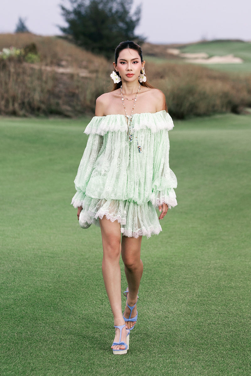 Valenciani off-shoulder lace mini dress displayed on a hanger, featuring delicate lace fabric and a stylish off-shoulder neckline.