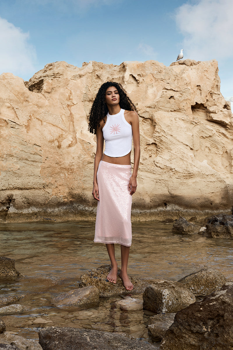 Pink midi skirt from IKINITA's Sunrise Skirt collection, featuring a flowy fabric and stylish design.