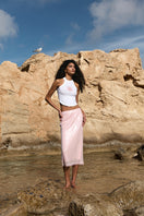 Pink midi skirt from IKINITA's Sunrise collection, featuring a flowy design and soft fabric for a stylish, feminine look.